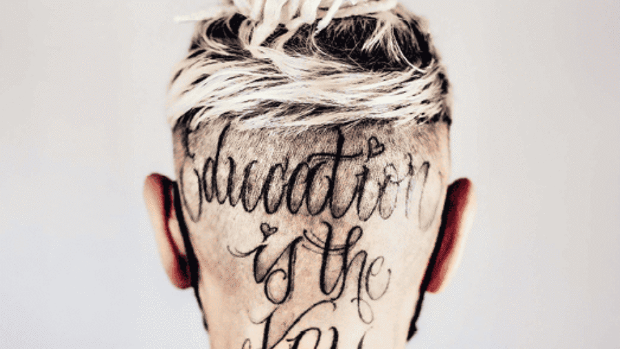 Hinteransicht eines Kopfes mit einem Haarschnitt und einer Tätowierung, die den Text 'education is the key' zeigt.