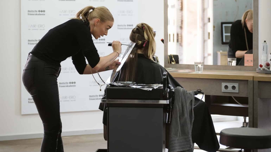 Friseurin schneidet die Haare einer Kundin in einem modernen Friseursalon.