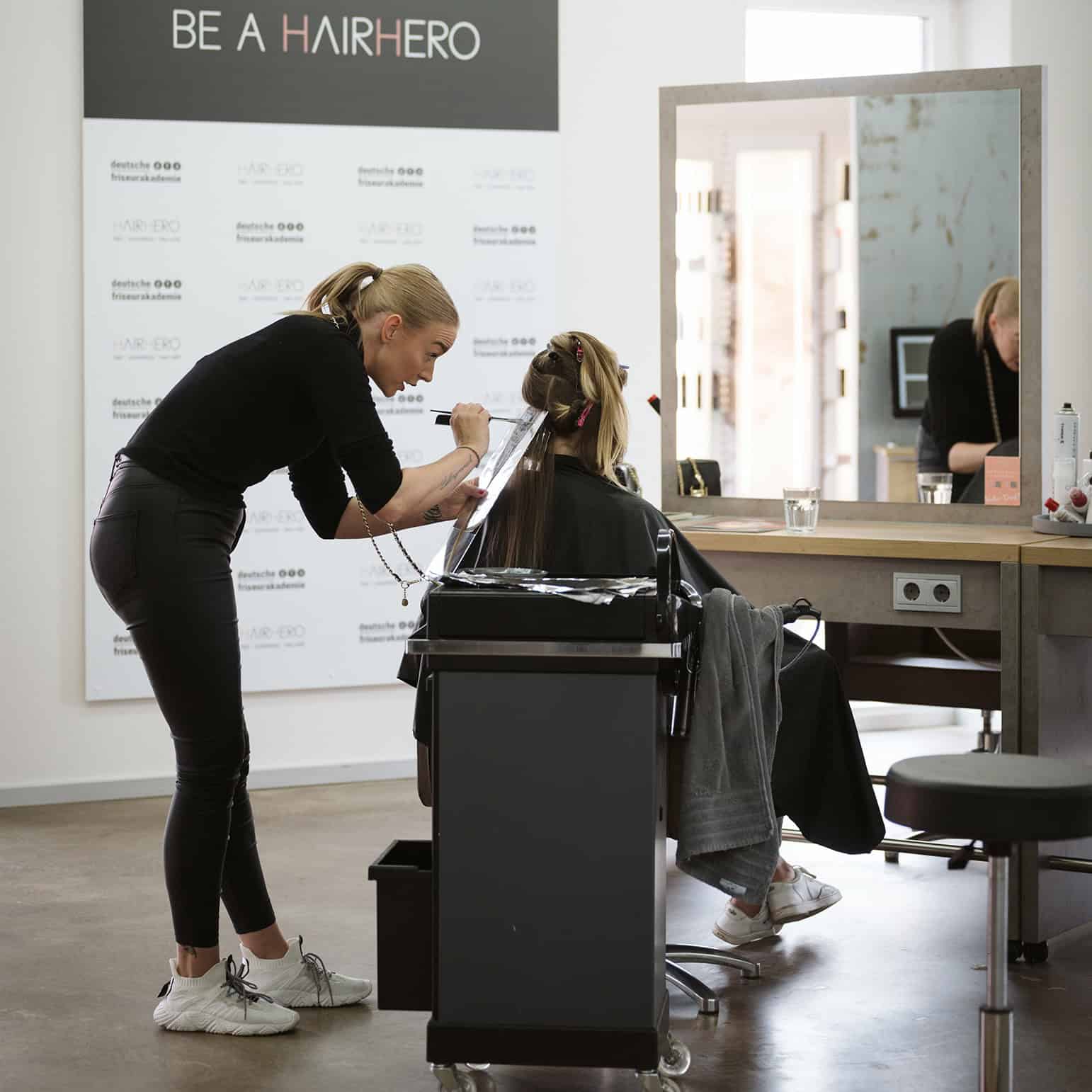 Friseurin schneidet die Haare einer Kundin in einem modernen Friseursalon.