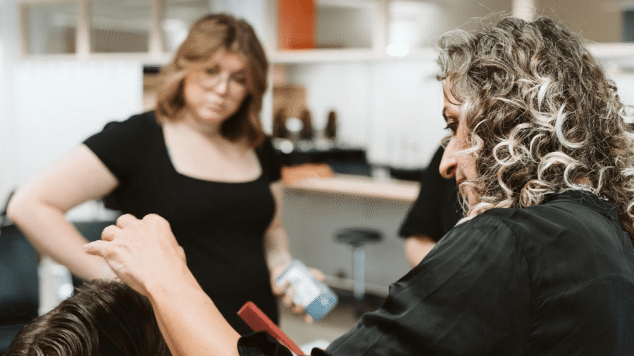Friseur schneidet das Haar einer Kundin in einem Friseursalon.