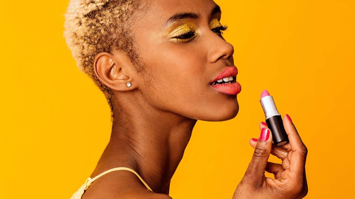 Geschminktes Model beim auftragen von Lippenstift